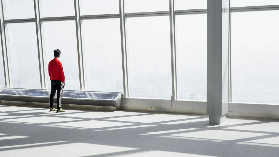 Man looking out of window in office building