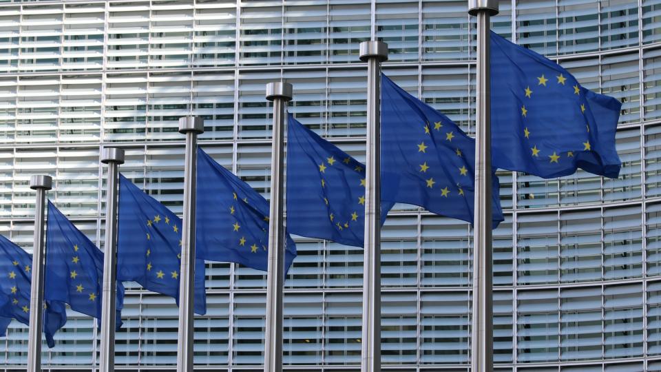 EU flags at the European Commission building in Brussels. Photo via Unsplash.